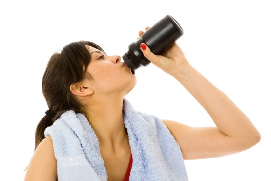 Woman drinking spring water after exercising
