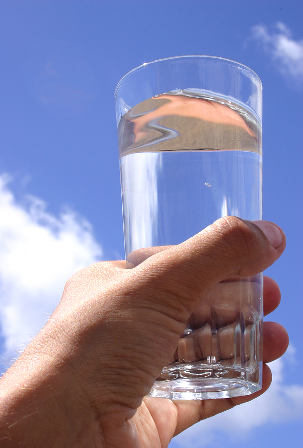 Hand raising glass of water