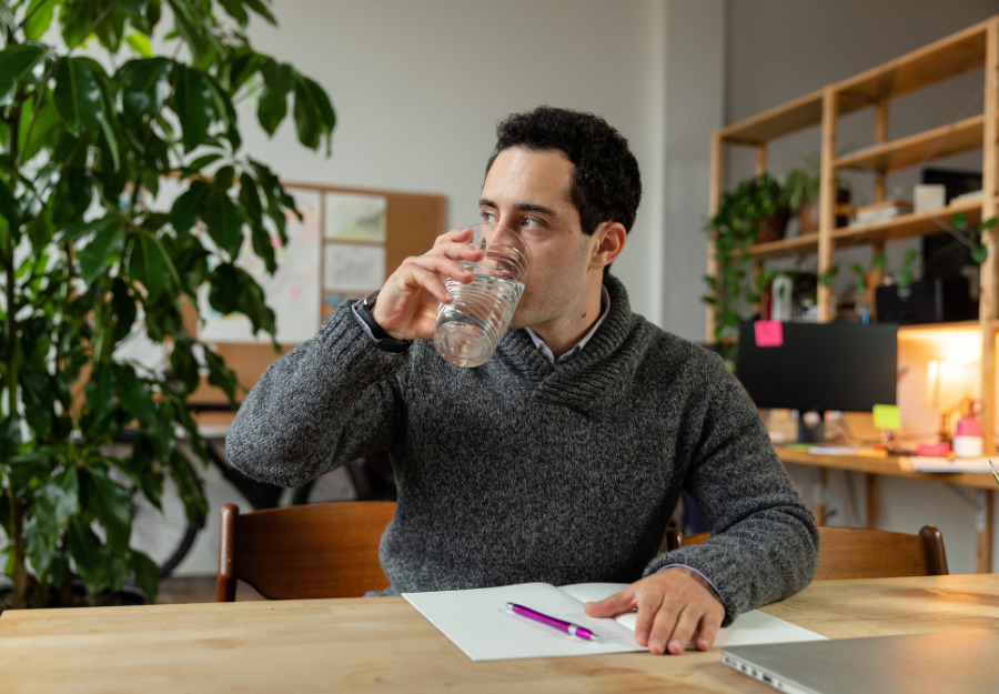 Man drinking water in office space