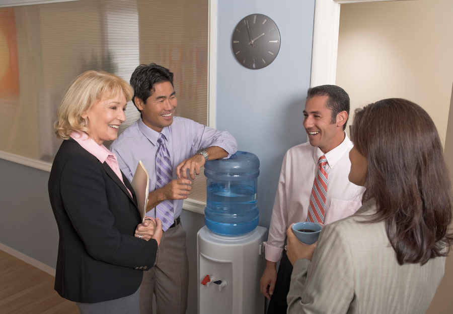 People gathered at their workplace water cooler