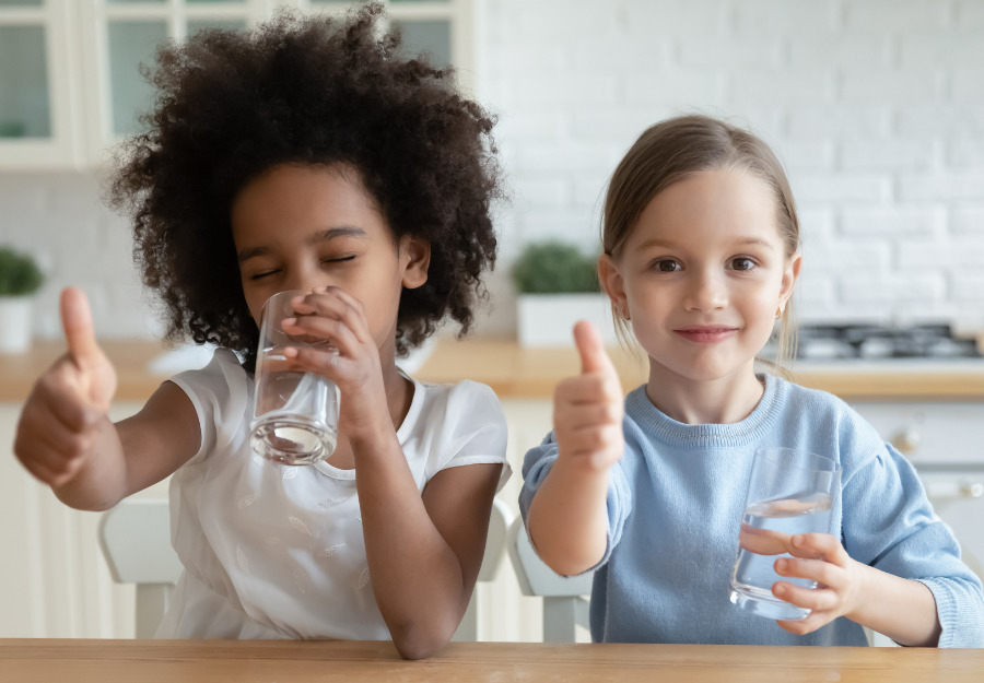 Drinking water benefits everyone - girls giving water thumbs up